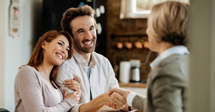 Couple smiling and embracing during consultation in their home.